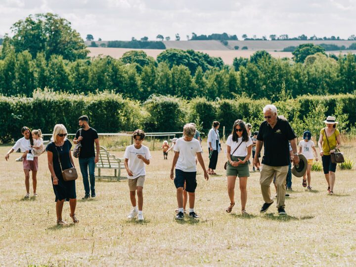 Image shows family walking through field on a tour