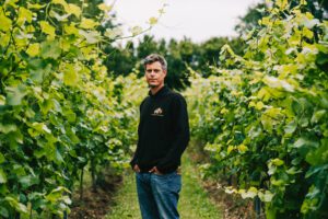 Paul Harrison standing in the vine rows