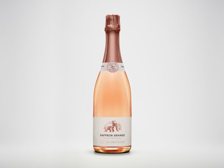 A bottle of the Saffron Grange sparkling rose in a clear bottle, on a white background